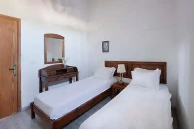 a bedroom with two beds and a dresser and a mirror at Cottage Houses in Pendakomo