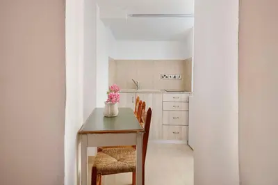 a dining room table with a vase of flowers on it at Cottage Houses in Pendakomo