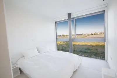 a bedroom with a white bed and a large window at White Pearl Villa 7 in Protaras