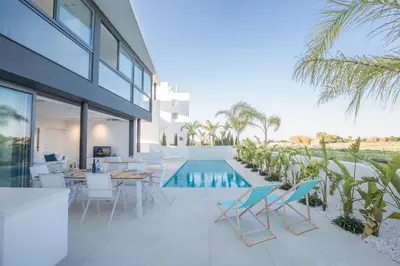 an outdoor patio with a table and chairs and a swimming pool at White Pearl Villa 7 in Protaras