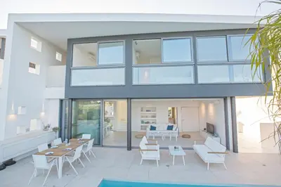 a glass house with white chairs and tables at White Pearl Villa 7 in Protaras