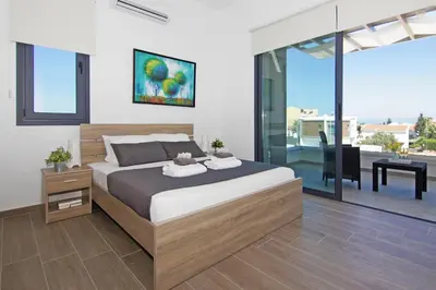 a bedroom with a large bed and a balcony at Villa Melody in Protaras