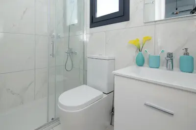 a white bathroom with a toilet and a shower at Villa Melody in Protaras