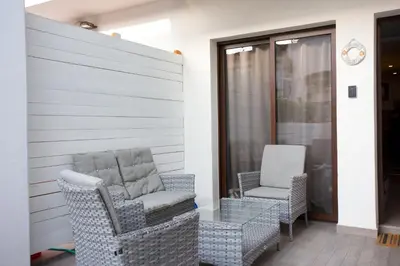 a patio with two chairs and aermottermottermottermott at Galatex Beach Living by TrulyCyprus in Limassol