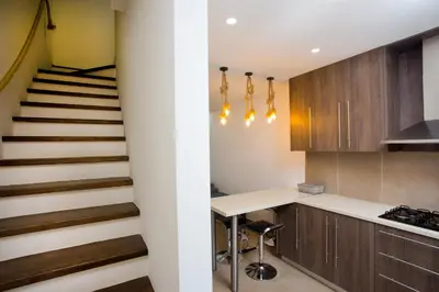 a kitchen with wooden cabinets and a staircase at Galatex Beach Living by TrulyCyprus in Limassol