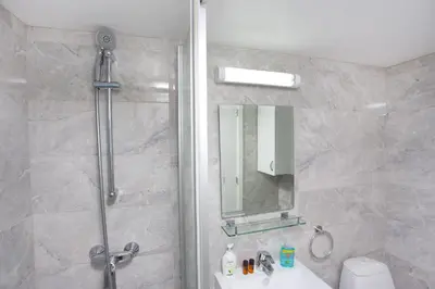 a bathroom with a shower and a sink and a mirror at Galatex Beach Living by TrulyCyprus in Limassol