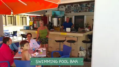 a group of people sitting at a table in a restaurant at CHRIS'S KYKLADES HOLIDAY APARTMENT in Paralimni