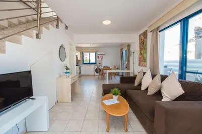 a living room with a couch and a table at Flouressia Gardens in Protaras