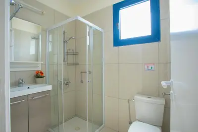 a bathroom with a shower and a toilet and a sink at Flouressia Gardens in Protaras