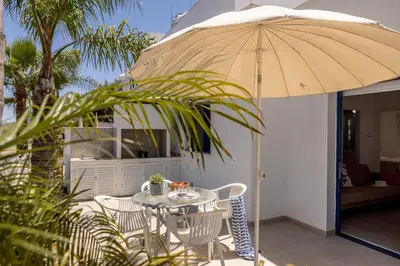 a table and chairs with an umbrella on a patio at Flouressia Gardens in Protaras