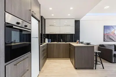 a kitchen with wooden cabinets and a stove top oven at Must Stay - Finikoudes Seaview in Larnaka