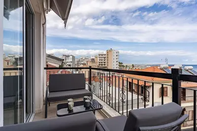 a balcony with a chair and a desk on a balcony at Must Stay - Finikoudes Seaview in Larnaka