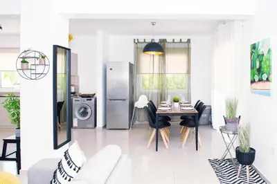 a living room with a table and a refrigerator at Nissini Nero, 3 bedroom villa with private pool, 5 min to the beach in Ayia Napa