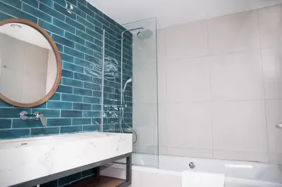 a bathroom with a mirror and a sink and a tub at Mandali Hotel in Protaras