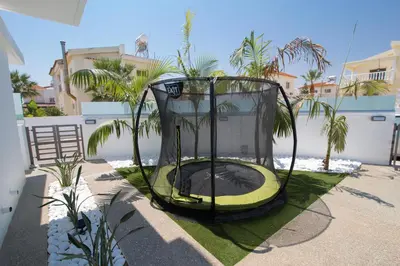 a black and yellow trampoline in a yard at Villa Lynn Boutique Beachfront in Ayia Napa