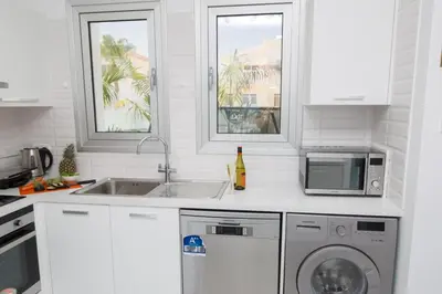 a white kitchen with a sink and a dishwasher at Villa Lynn Boutique Beachfront in Ayia Napa