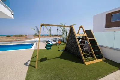 a swing set on the side of a house at Villa Lynn Boutique Beachfront in Ayia Napa