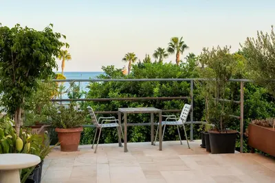 a patio with a table and chairs and the ocean at City Centre Rooms in Limassol
