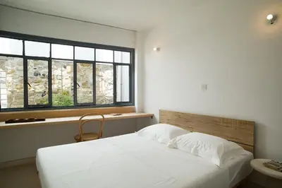 a bedroom with a white bed and a window at City Centre Rooms in Limassol
