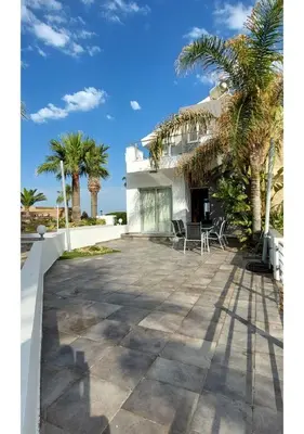 a house with palm trees in front of it at Villa Sorelle in Protaras