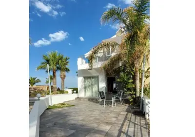 a house with palm trees and a patio at Villa Sorelle in Protaras