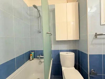 a bathroom with a toilet and a cabinet and a tub at Lovely holiday home,Kapparis,2 swimming pools,Wifi in Paralimni