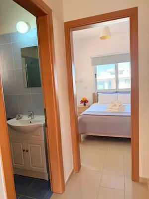 a bathroom with a bed and a sink and a mirror at Lovely holiday home,Kapparis,2 swimming pools,Wifi in Paralimni