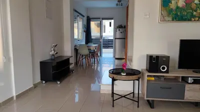 a living room with a television and a table at Lovely holiday home,Kapparis,2 swimming pools,Wifi in Paralimni