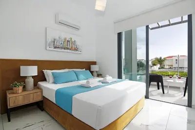 a bedroom with a large bed and a balcony at Villa Martha in Protaras