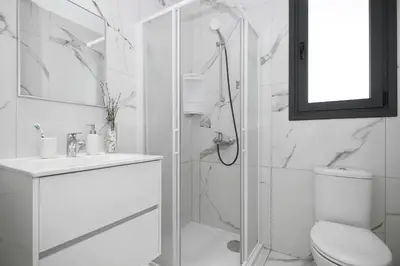 a white bathroom with a shower and a toilet at Villa Martha in Protaras