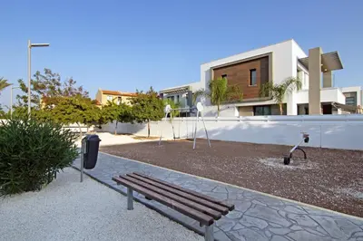 a park with a bench in front of a building at Villa Martha in Protaras