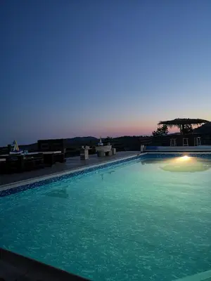 a large swimming pool with green water at night at Kalamospito Holiday House in Kalokhorio