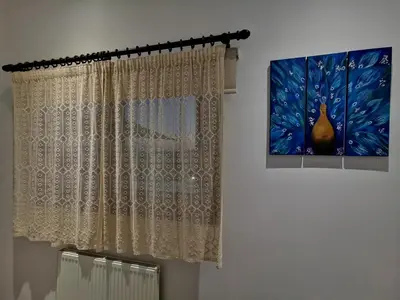 a room with a window with a curtain and a painting at Kalamospito Holiday House in Kalokhorio