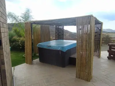 a hot tub in a pergola on a patio at Kalamospito Holiday House in Kalokhorio