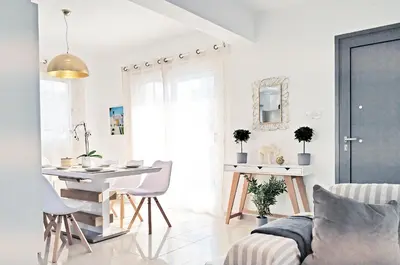 a white living room with a table and a dining room at Nissini Blanco, 3 bedroom villa with private pool, 5 min to the beach in Ayia Napa