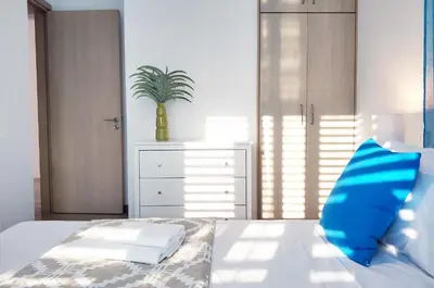 a bedroom with a bed with a blue pillow on it at Nissini Blanco, 3 bedroom villa with private pool, 5 min to the beach in Ayia Napa