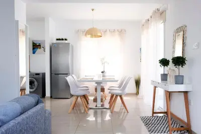 a living room with a table and white chairs at Nissini Blanco, 3 bedroom villa with private pool, 5 min to the beach in Ayia Napa