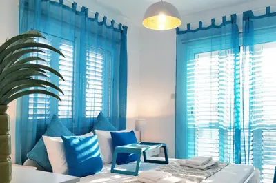 a blue bedroom with a bed with blue curtains at Nissini Blanco, 3 bedroom villa with private pool, 5 min to the beach in Ayia Napa
