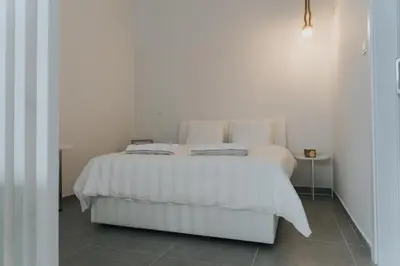 a white bed with two pillows on it in a bedroom at Prima Gardens City Studios in Larnaka