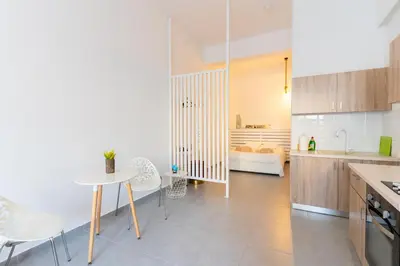 a kitchen with a table and chairs in a room at Prima Gardens City Studios in Larnaka