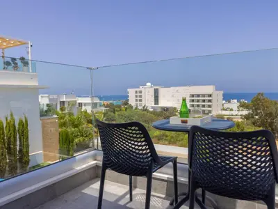 a patio with two chairs and a table on a balcony at Milos lifestyle villa H30 in Protaras