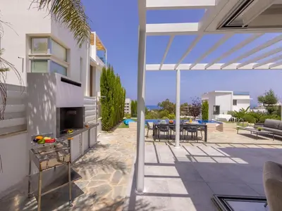 a patio of a house with a table and chairs at Milos lifestyle villa H30 in Protaras