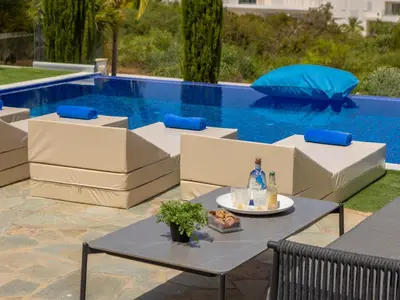 a patio with a table and chairs next to a pool at Milos lifestyle villa H30 in Protaras