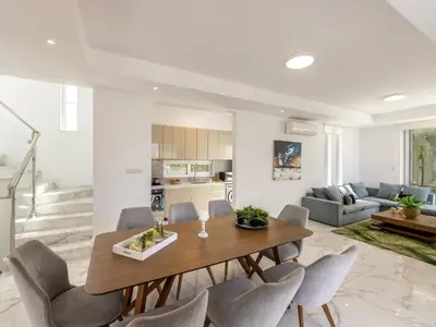 a dining room and living room with a table and chairs at Milos lifestyle villa H30 in Protaras