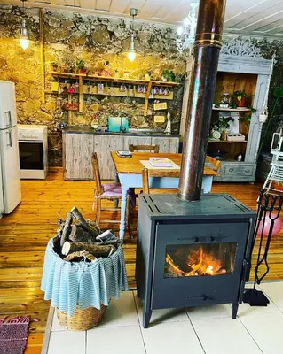 a fireplace in a kitchen with a table and a dining room at Holiday House Prodromos in Prodromos
