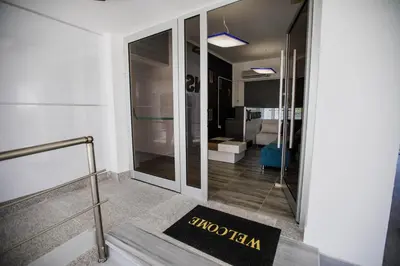 a hallway with a glass door and a welcome mat at Twins Apartments in Kato Pyrgos