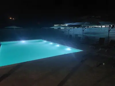 a swimming pool at night with blue lights at Twins Apartments in Kato Pyrgos