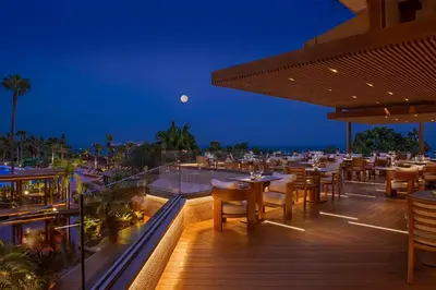 a restaurant with tables and chairs on a deck at night at Four Seasons Hotel in Limassol
