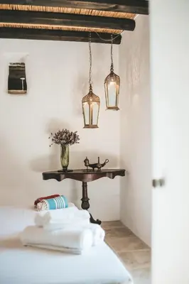 a table with a vase of flowers and two lights at CASAVERO in Voroklini