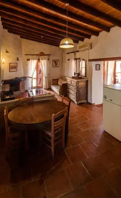 a large kitchen with a table and a refrigerator at Linos Inn in Kakopetria